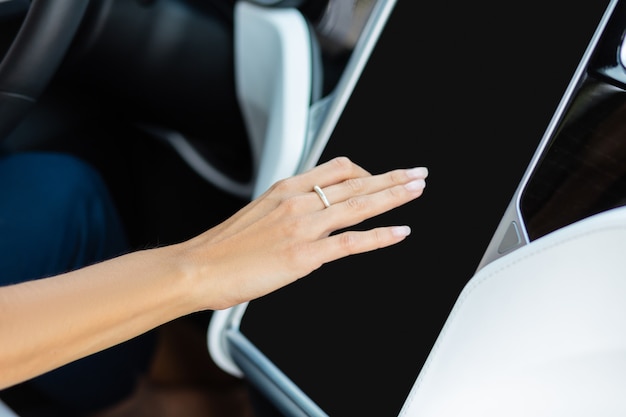 Zdjęcie system nawigacyjny. zbliżenie na kobietę noszącą ładny pierścionek za pomocą systemu nawigacyjnego w swoim samochodzie