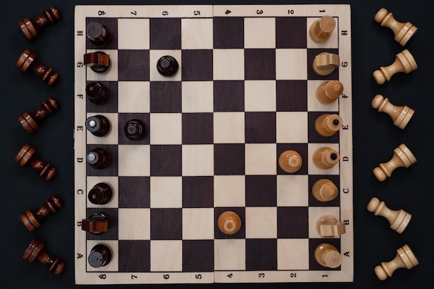 szachownica z figurami na czarnym tle widok z góry