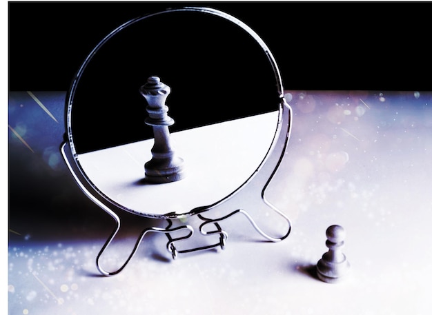 Zdjęcie szachowy pionek patrząc w lustro i widząc królową