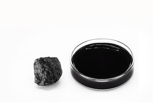 Szalka Petriego z olejem opałowym naftowym izolowane białe tło z kamiennym koksem naftowym rudy produktów ropopochodnych i produktów rafinowanych do użytku przemysłowego