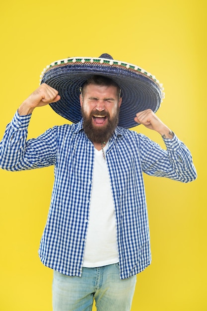 Szalony na punkcie swojego sombrero Brodaty mężczyzna w meksykańskim kapeluszu Hipster w kapeluszu z szerokim rondem Meksykanin ubrany w sombrero Tradycyjny modny dodatek na meksykańskie przyjęcie kostiumowe Jest zakochany w meksykańskim stylu