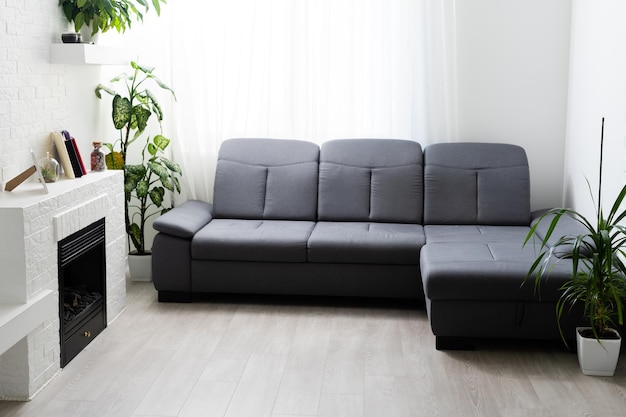 Zdjęcie szara sofa przy kominku w salonie.