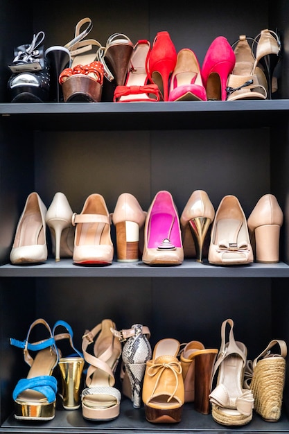 Szare półki w szafie pełne modnych kobiecych butów na szpilkach organizacja przechowywania pary szafek