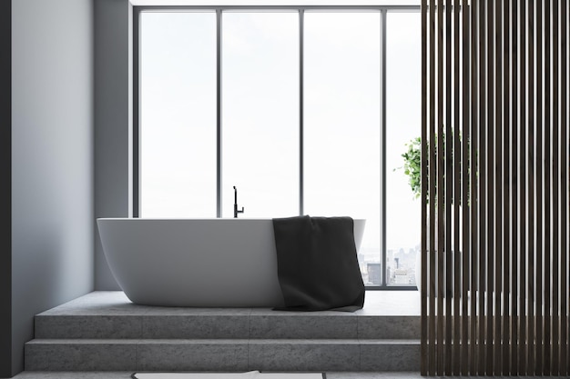 Szare wnętrze łazienki z betonową podłogą, okrągłą białą wanną i panoramicznym oknem. Makieta renderowania 3D