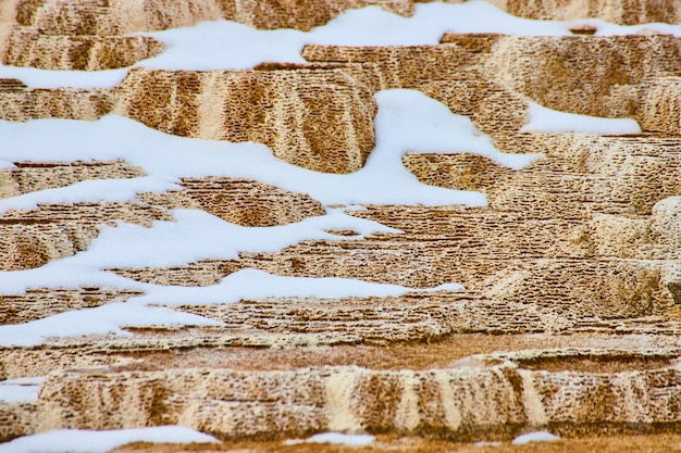 Szczegółowo tarasy z gorącymi źródłami Yellowstone z łatami śniegu
