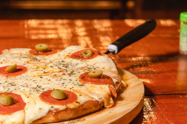 Szczegółowy widok pizzy pepperoni na drewnianym stole