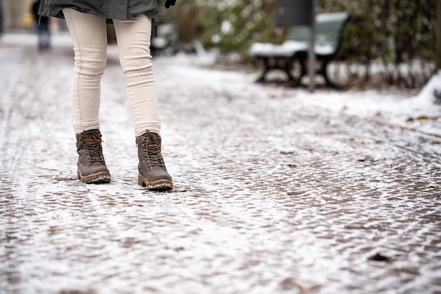 Szczegóły butów nierozpoznawalnej kobiety chodzącej po śniegu zimą koncepcja butów moda zimowa