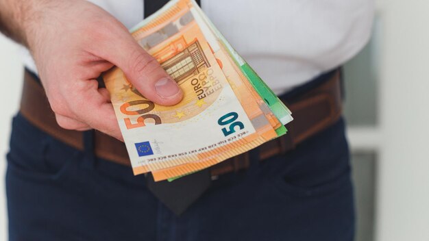 Szczegóły rąk człowieka z banknotami euro pieniędzy
