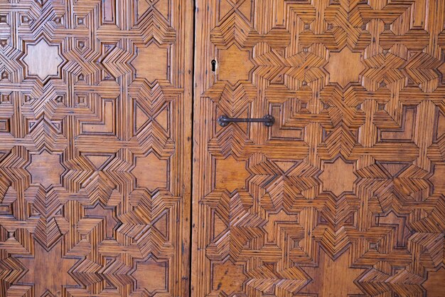 Zdjęcie szczegóły rzeźbionych drewnianych drzwi w alhambra, granada, hiszpania. arabskie drzwi wyrzeźbione w stylu islamskim.