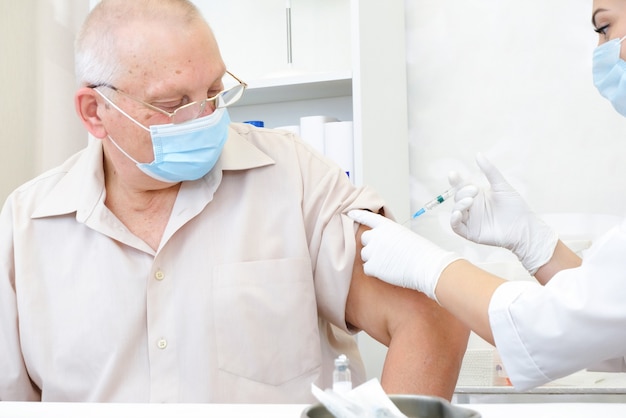 Zdjęcie szczepienie osoby dorosłej w szpitalu. koncepcja opieki zdrowotnej, szczepionka na koronawirusa