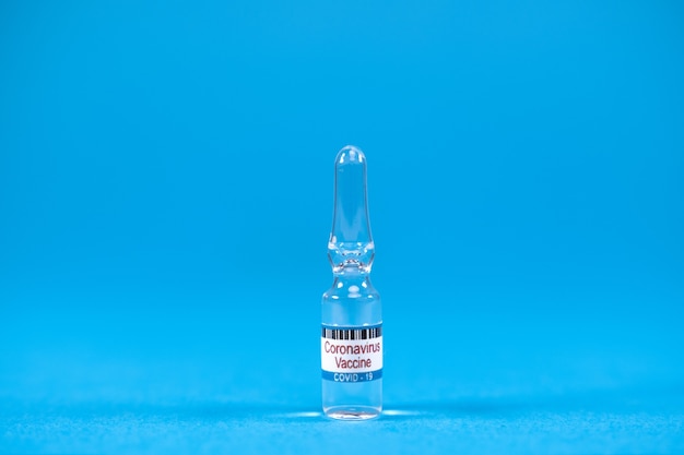 Zdjęcie szczepionka wynalazcza ze szklanych ampułek ncov do wstrzykiwania szczepionki koronawirusowej na niebieskim tle z miejscem na tekst koncepcja walki z sarsncovem szczepienia ludzi przeciwko wirusowi covid