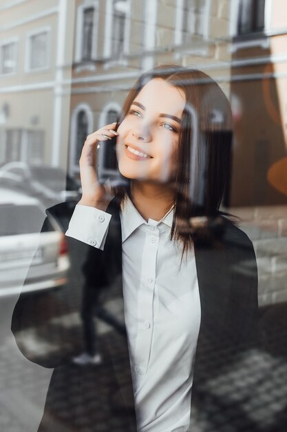 Szczery wizerunek businesswoman rozmawia przez telefon w kawiarni. Szczęśliwy słoneczny dzień!