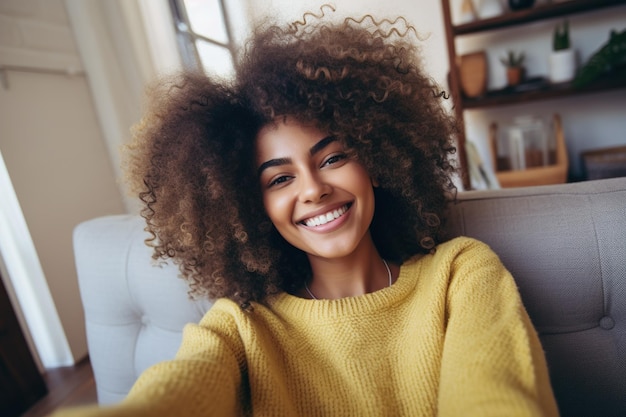 Szczęśliwa afro Amerykanka relaksuje się na kanapie w domu Dziewczyna robi sobie zdjęcie selfie ze smartfonem