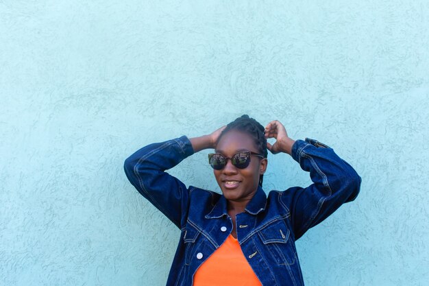 Szczęśliwa Afroamerykanka przed niebieską ścianą