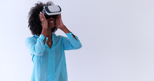 Szczęśliwa Afroamerykanka zdobywająca doświadczenie w okularach wirtualnej rzeczywistości, izolowana na białym tle