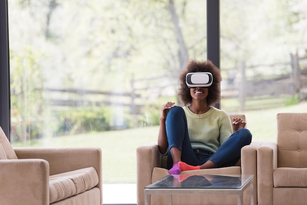 Szczęśliwa afroamerykańska dziewczyna zdobywająca doświadczenie w korzystaniu z okularów VR wirtualnej rzeczywistości w domu