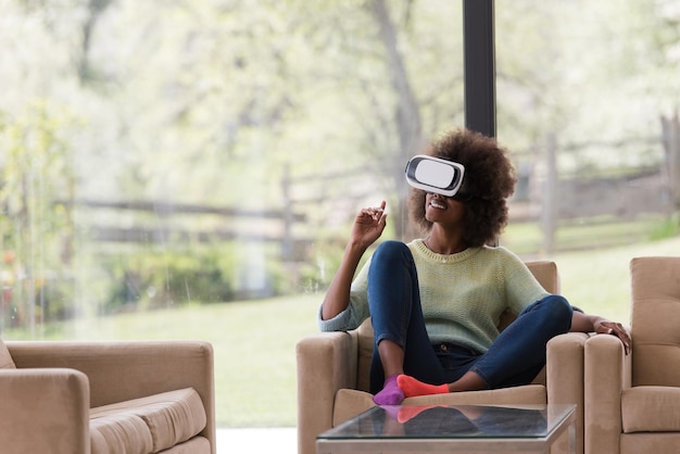 Szczęśliwa afroamerykańska dziewczyna zdobywająca doświadczenie w korzystaniu z okularów VR wirtualnej rzeczywistości w domu