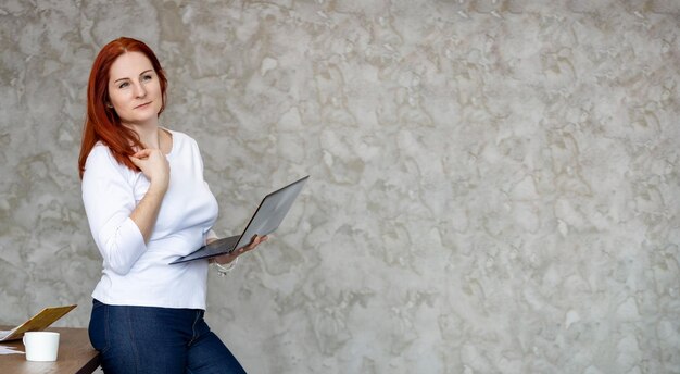 Zdjęcie szczęśliwa atrakcyjna kobieta z banerem laptopa, banerem edukacyjnym dla pracy zdalnej lub usługi naprawczej