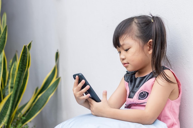 Szczęśliwa Azjatycka Dziewczynka Oglądająca I Używająca Smartfona