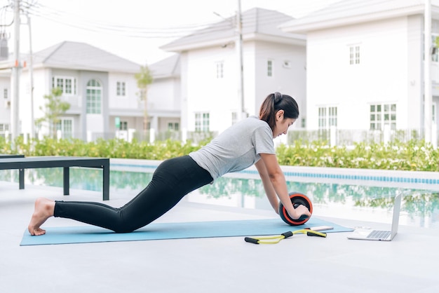 Szczęśliwa azjatycka kobieta ćwiczenia rozciągające i ćwiczenia jogi rano w domu