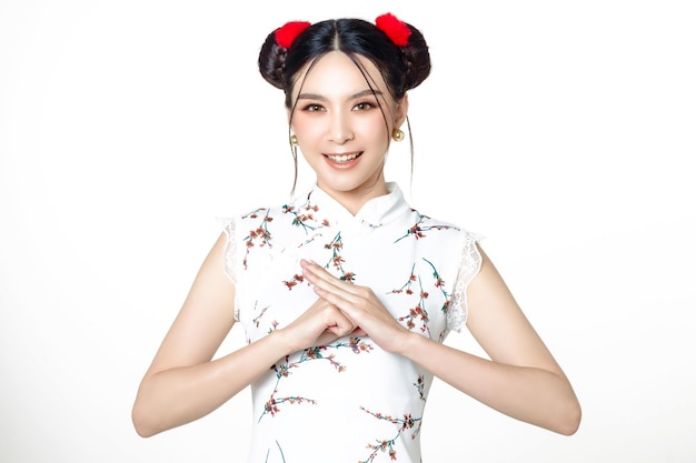 Szczęśliwa Azjatycka kobieta ubrana w chińską tradycyjną sukienkę qipao cheongsam z gestem gratulacji