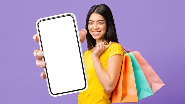 Szczęśliwa Azjatycka Kobieta Z Torby Na Zakupy Wykazująca Pusty Ekran Smartfona