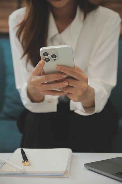 Zdjęcie szczęśliwa azjatycka nastolatka trzymająca gadżet komputerowy za pomocą technologii tabletu cyfrowego siedząca na kanapie w domu uśmiechnięta młoda kobieta korzystająca z aplikacji robiących zakupy online czytająca wiadomości przeglądająca internet na kanapie