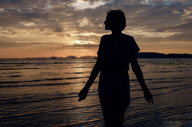 Szczęśliwa beztroska kobieta korzystających piękny zachód słońca na plaży