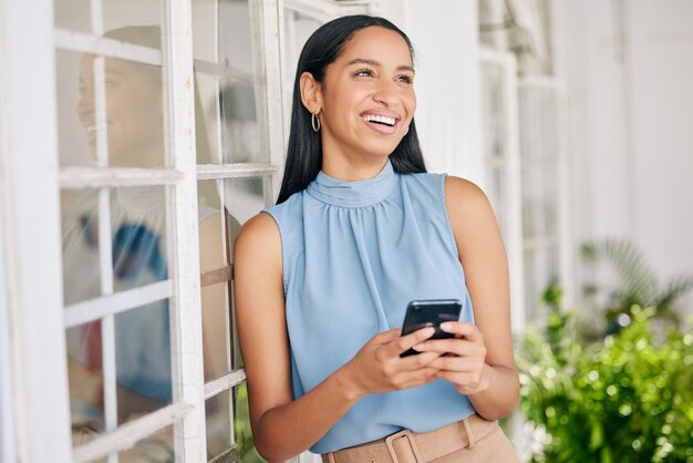 Szczęśliwa biznesmenka rozmawiająca przez telefon komórkowy online z uśmiechem i wpisując e-mail na smartfonie 5g w biurze na zewnątrz w pracy Kierownik i pracownik korporacyjny na stronie internetowej i aplikacji internetowej