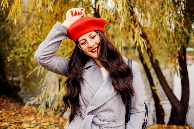 Szczęśliwa brunetka kobieta w stylowym czerwonym berecie