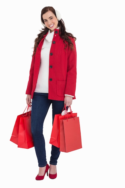 Szczęśliwa brunetka w zimy mienia odzieżowych torba na zakupy
