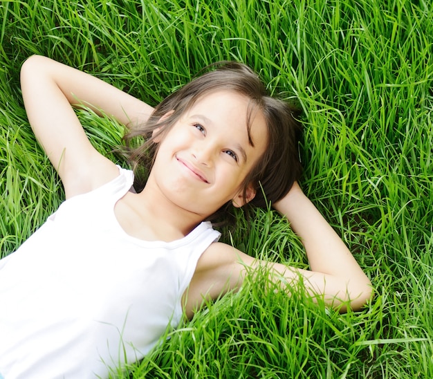 Szczęśliwa chłopiec cieszy się na trawy polu i marzyć