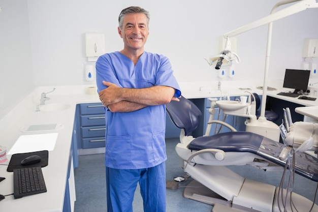 Szczęśliwa dentysta pozycja z rękami krzyżować