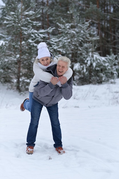 Szczęśliwa dojrzała para bawi się zimą na świeżym powietrzu