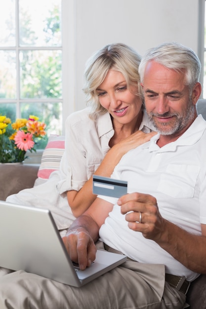 Szczęśliwa dojrzała para robi online zakupy w domu