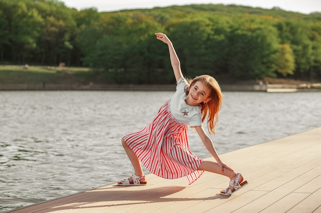 Szczęśliwa dziewczyna biega i skacze na nabrzeżu Radość z wolności natury Życie po kwarantannie
