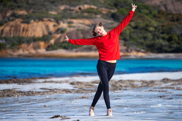szczęśliwa dziewczyna biega i skacze na plaży Lucky Bay w zachodniej australii słoneczny dzień na rajskiej plaży