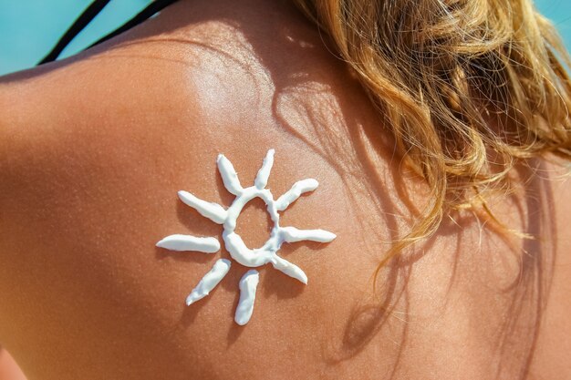 Szczęśliwa dziewczyna nad morzem ze zdjęciem słońca na plecach