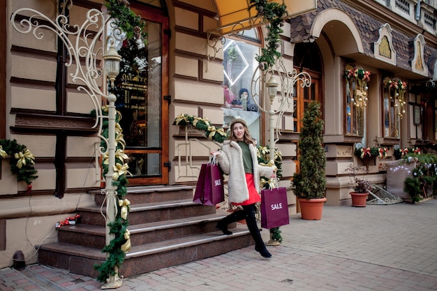 Szczęśliwa Dziewczyna Trzyma Papierowe Torby Z Symbolem Sprzedaży W Sklepach Z Wyprzedażami Na Boże Narodzenie W Całym Mieście