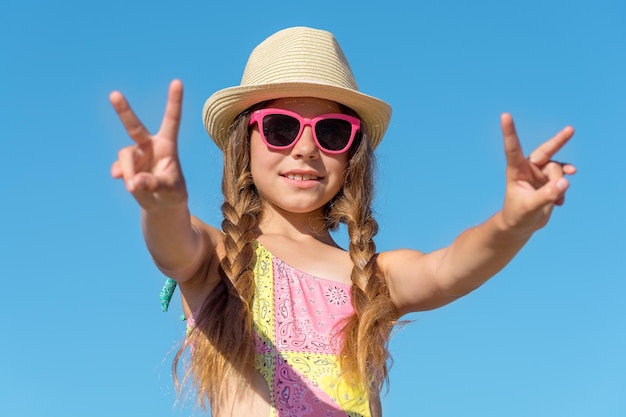 Zdjęcie szczęśliwa dziewczyna w okularach z podniesionymi rękami do nieba.