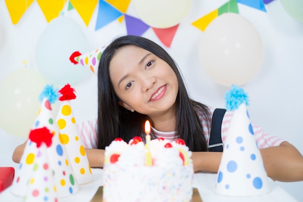 Zdjęcie szczęśliwa dziewczyna z ciastem na urodziny party.