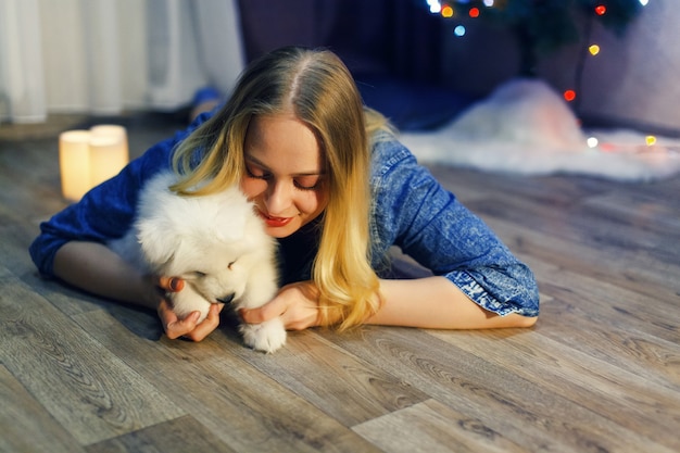 Szczęśliwa dziewczyna z samoyedem husky w ozdób choinkowych