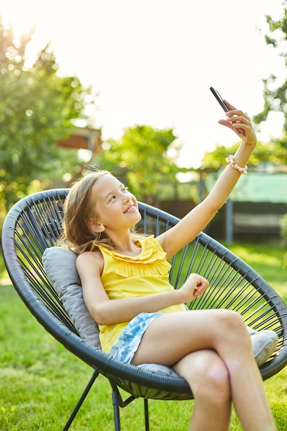 Szczęśliwa Dziewczynka Bierze Selfie Na Telefon Komórkowy W Parku Na świeżym Powietrzu