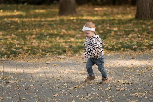 Zdjęcie szczęśliwa dziewczynka w jesiennym parku śmieje się