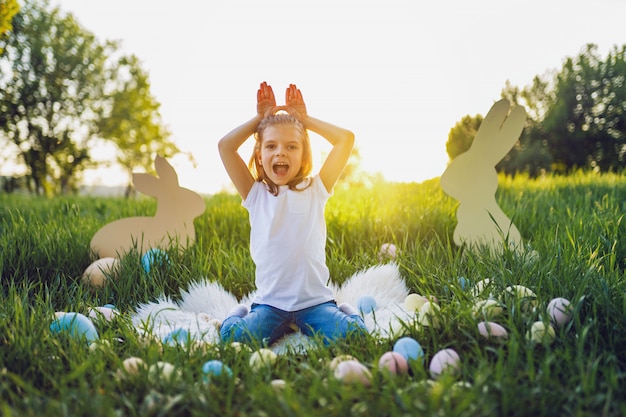 Szczęśliwa Easter dziewczyna robi królików ucho z rękami