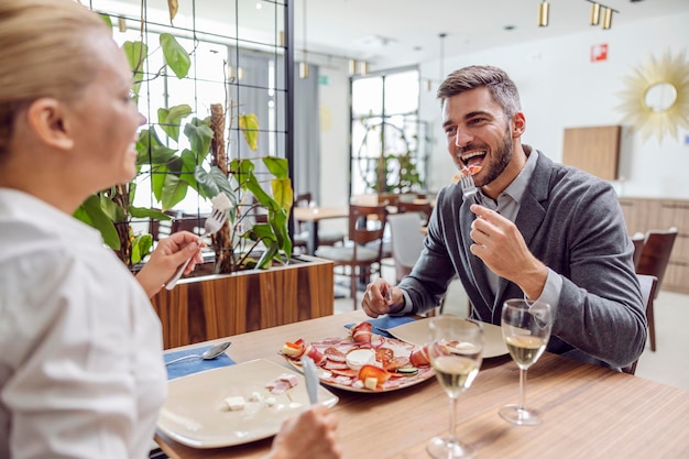 Szczęśliwa elegancka para o romantyczny obiad w eleganckiej restauracji Para jedzenia w restauracji