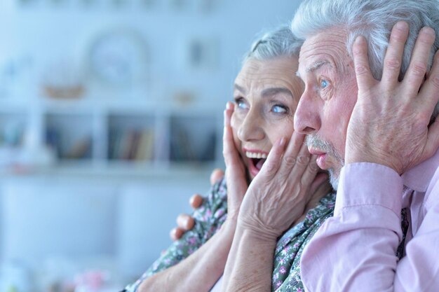 Szczęśliwa emocjonalna para seniorów pozuje w domu