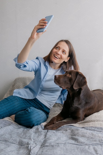 Szczęśliwa europejska kobieta i jej pies labrador retriever w domuszczęśliwa europejska kobieta i jej labrador