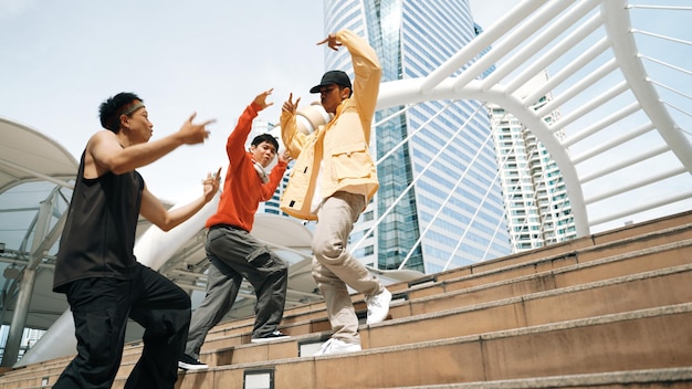 Szczęśliwa grupa hipsterów wchodząca po schodach podczas tańca ulicznego Sprightly