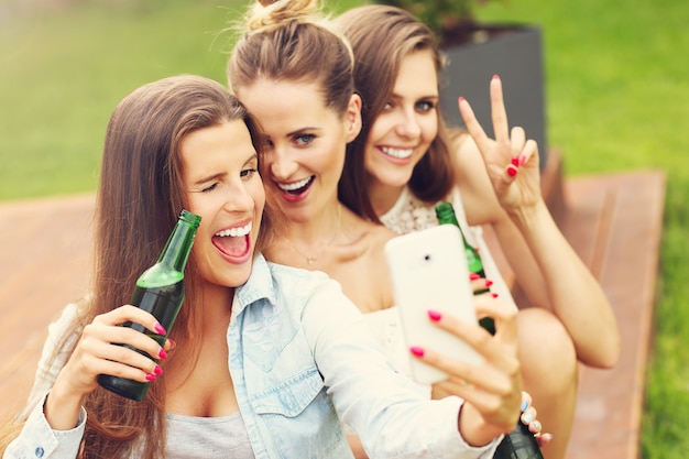 szczęśliwa grupa przyjaciół pijąca piwo na świeżym powietrzu